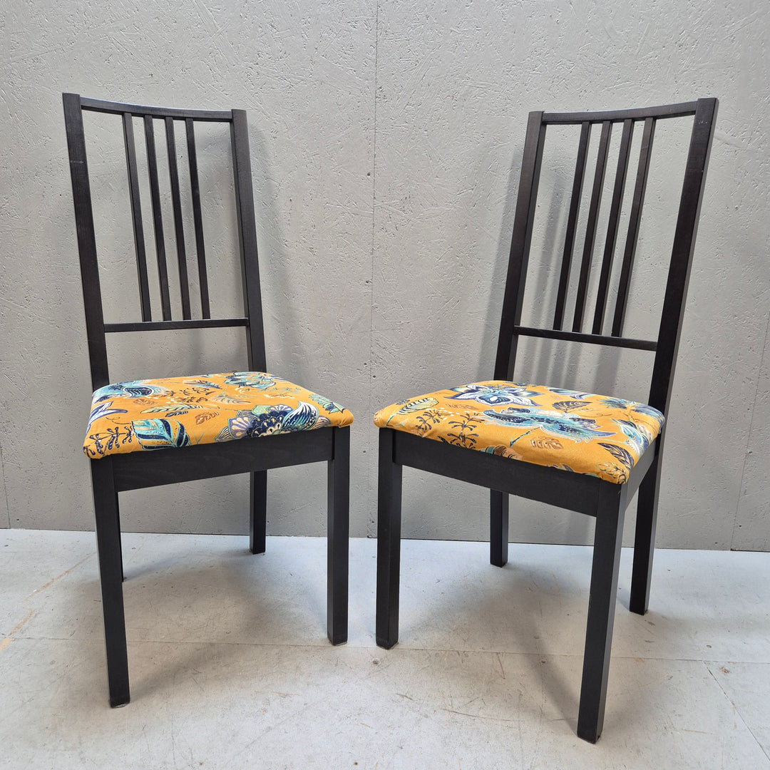 Svarta stolar med mönstrade sittdynor