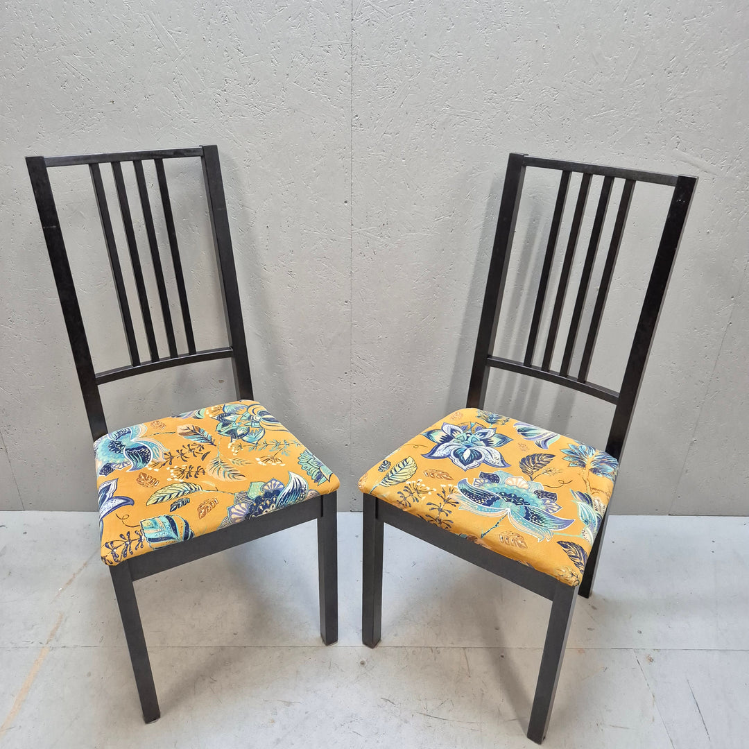 Svarta stolar med mönstrade sittdynor