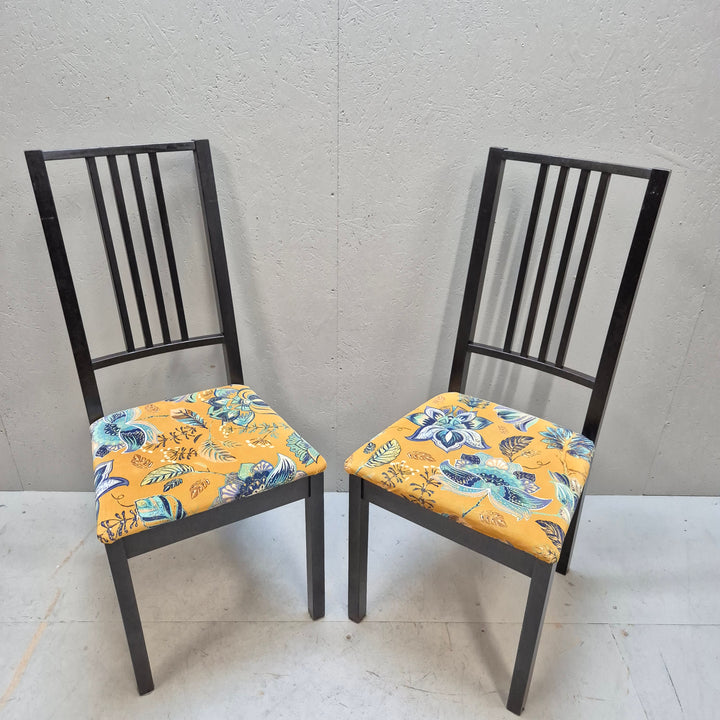 Svarta stolar med mönstrade sittdynor