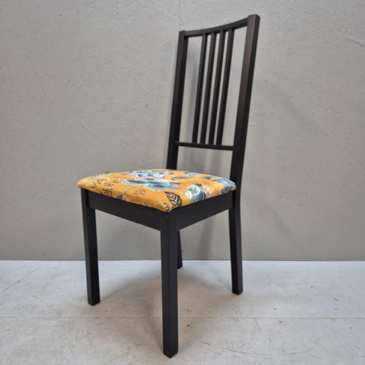 Svarta stolar med mönstrade sittdynor