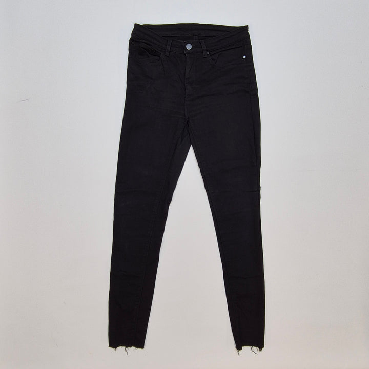Svarta jeans med slitna detaljer