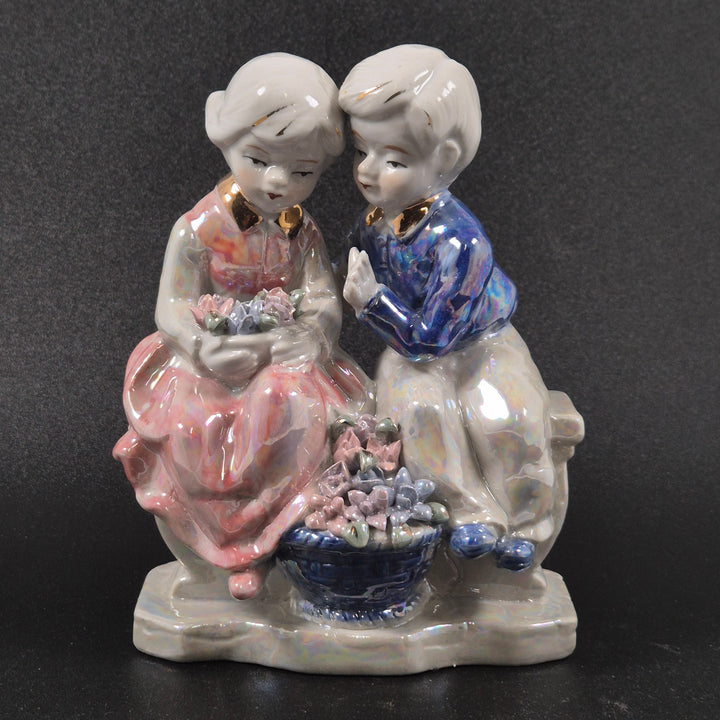 Retro porslinsfigur av två barn med blommor