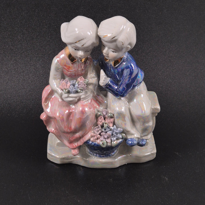 Retro porslinsfigur av två barn med blommor
