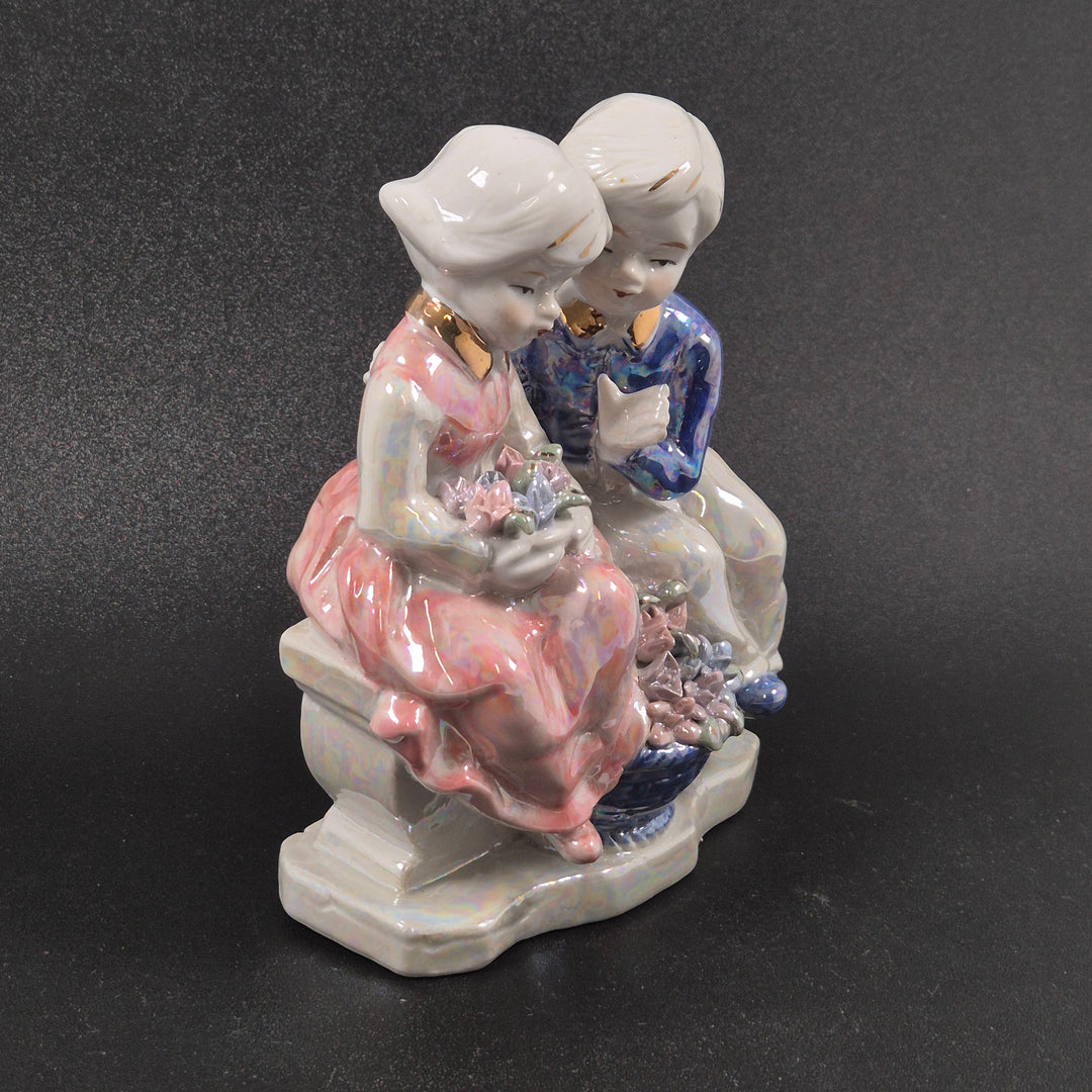 Retro porslinsfigur av två barn med blommor