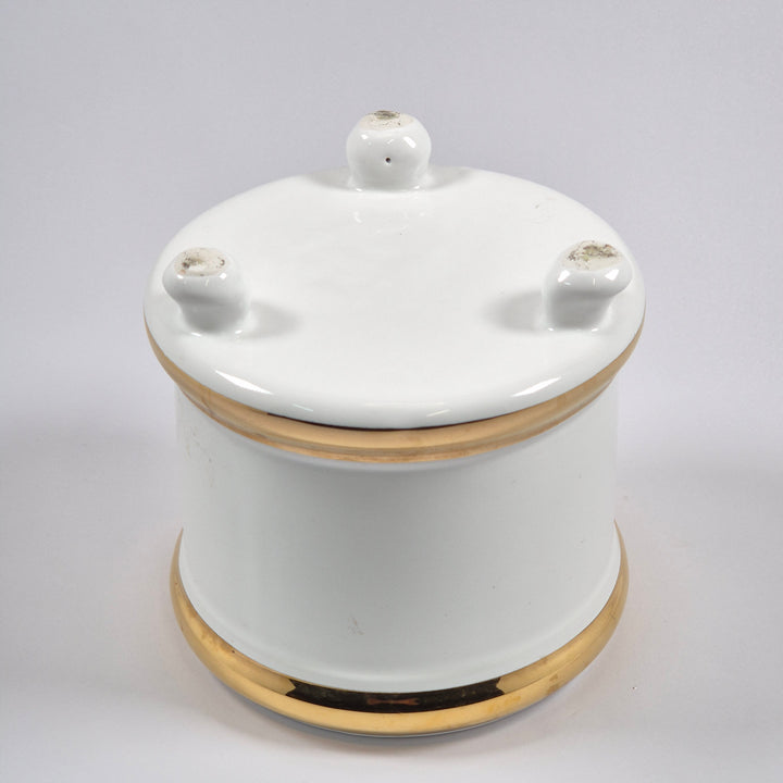 Elegant vit porslinskruka med guldfärgade kanter