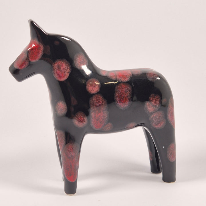 Svart keramik hästfigur med röda prickar