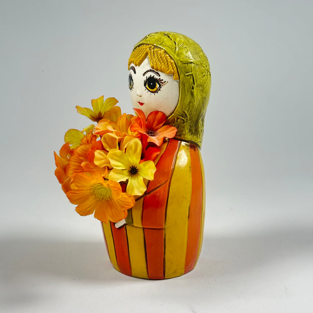 Charmig Docka i Blomkruka med Färgglada Blommor