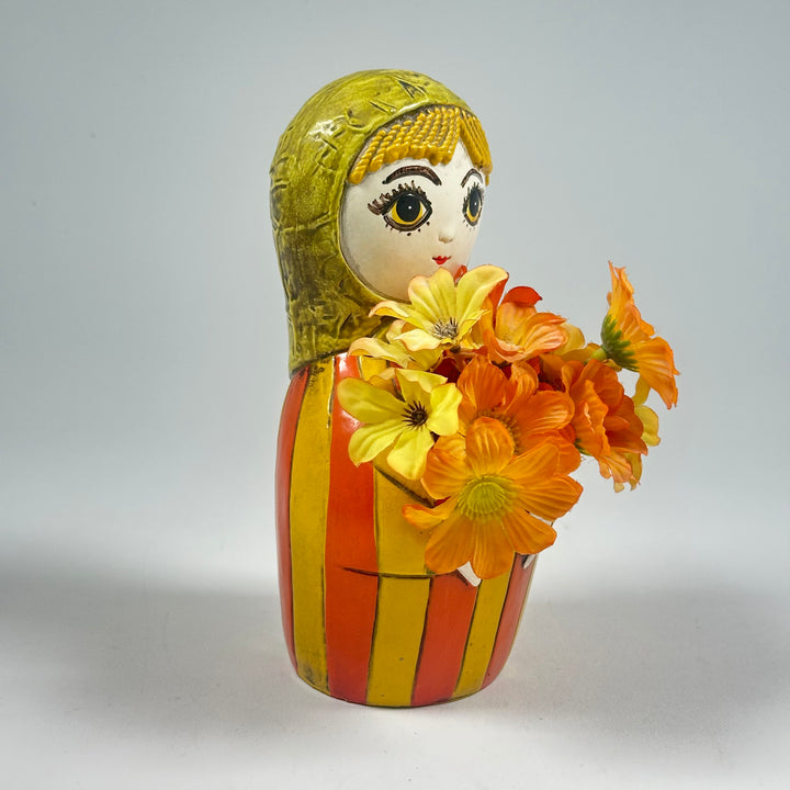 Charmig Docka i Blomkruka med Färgglada Blommor