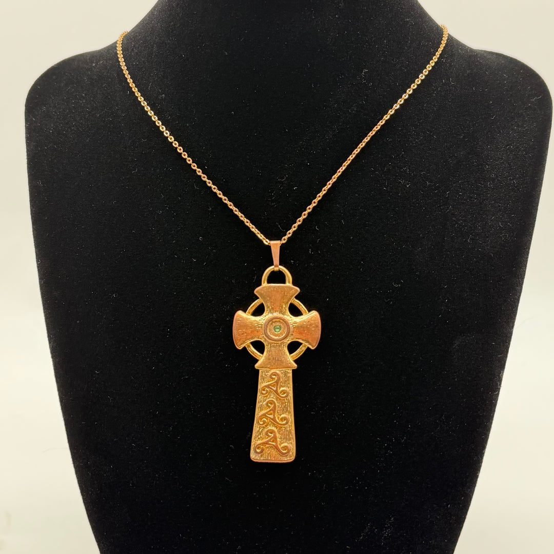 Förtrollande korshänge med grön sten i guldton