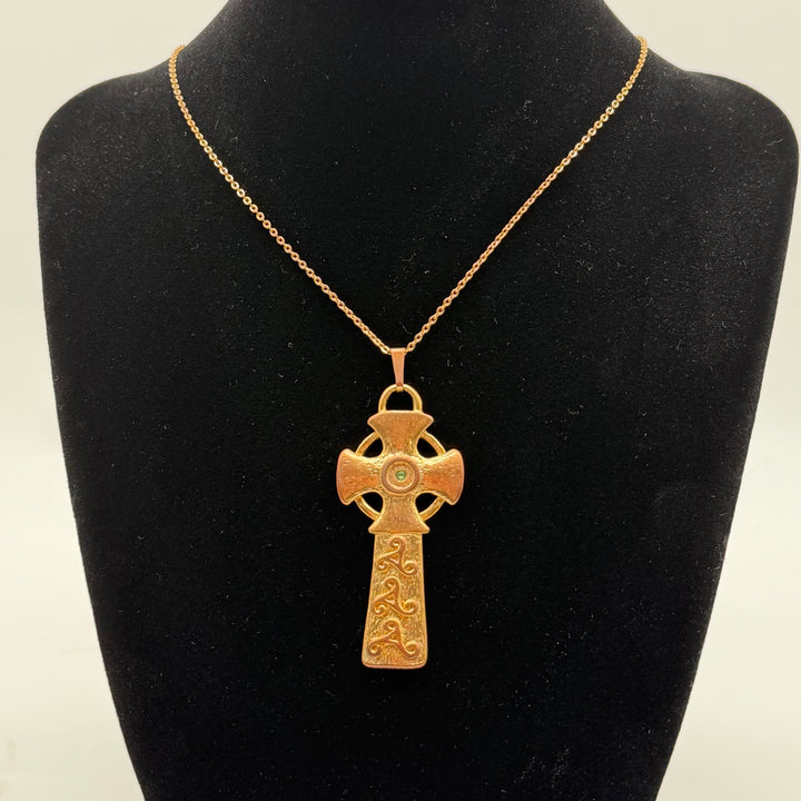 Förtrollande korshänge med grön sten i guldton