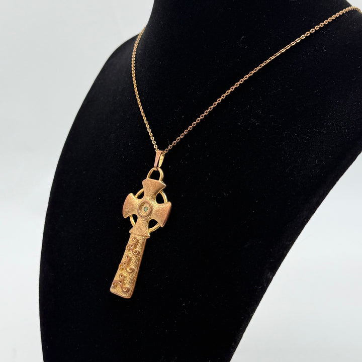 Förtrollande korshänge med grön sten i guldton