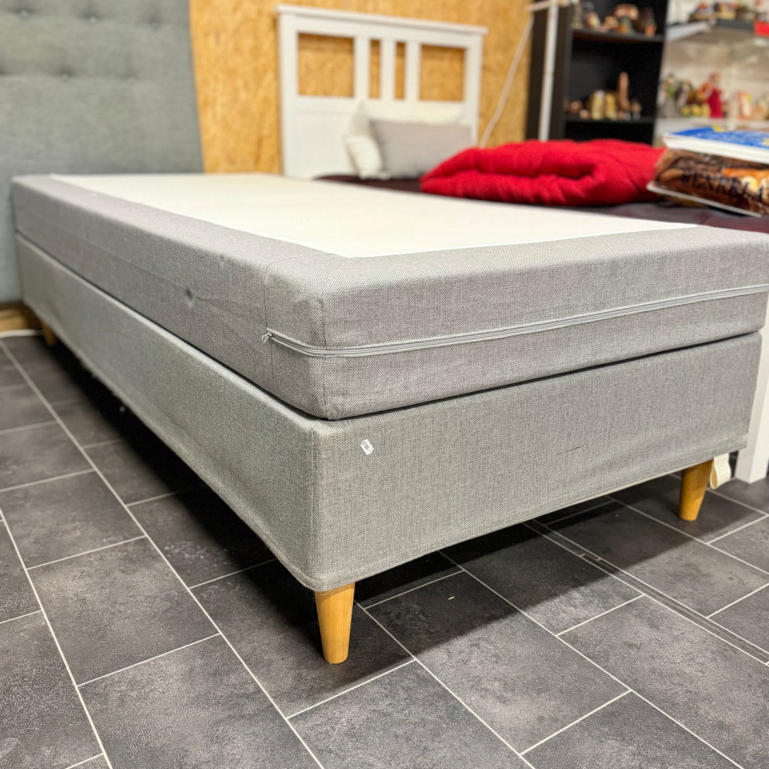 Modern grå enkelsäng med träben