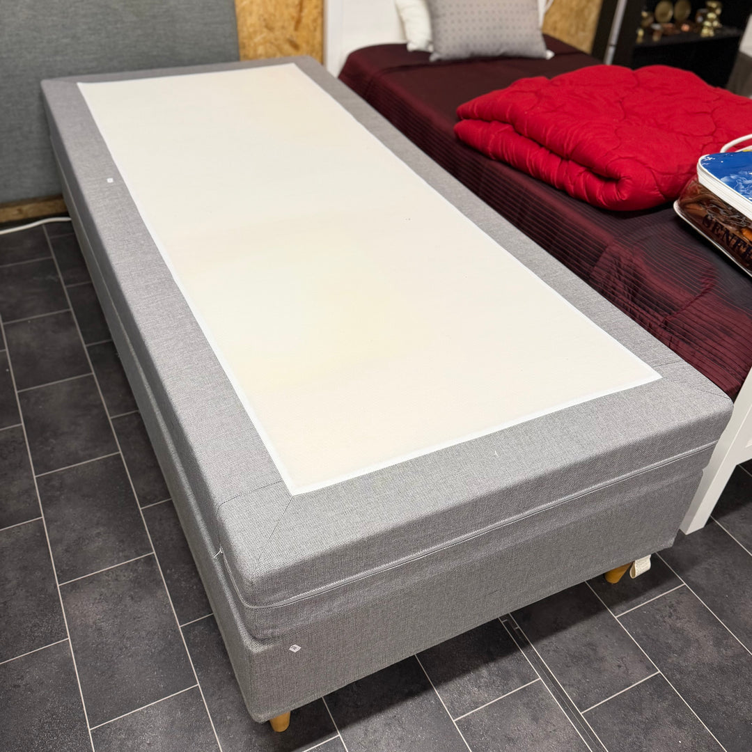 Modern grå enkelsäng med träben