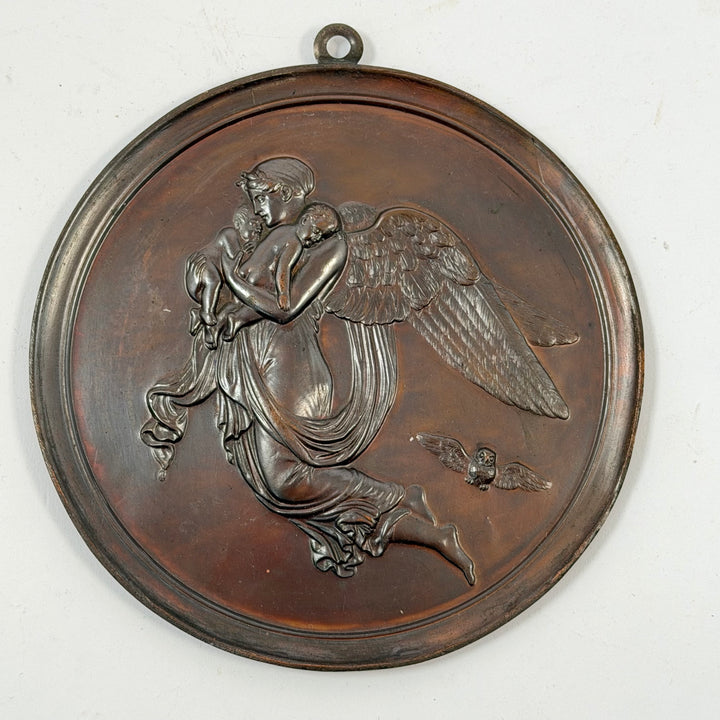 Runda bronsfärgade väggplaketter med änglamotiv